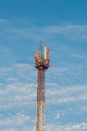 Cell tower of mobile communication with antennas transmitters against the background of clear blue skyの写真素材
