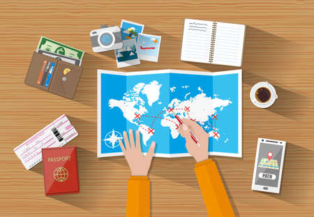 cartoon mans hands at table with paper map of world and tourist equipment. passport, airplane...
