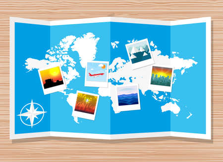 Wooden travellers desk with folded paper map of world and photos. travel and vacation concept....