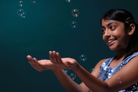 adorable girl catchs blowing soap bubbles
