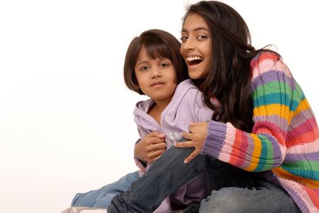 joyful indian sisters over white background