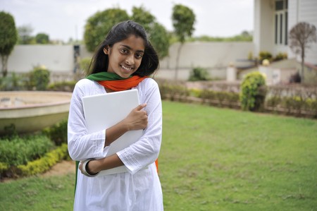 indian girl holding laptop outdoorsの写真素材