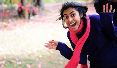 Indian girl showing expression in autumn parkの写真素材