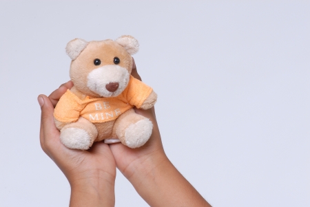Hands holding small teddy bearの写真素材