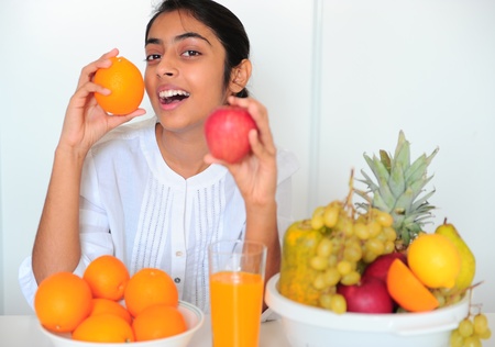 The beautiful Indian girl with fruits at homeの写真素材
