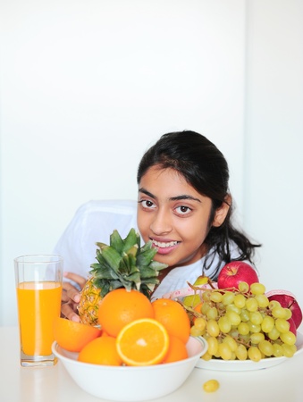 Beautiful Indian girl holding fruits and a measure tapeの写真素材