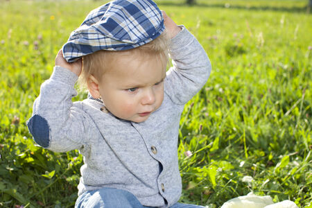 Little boy putting on his cap