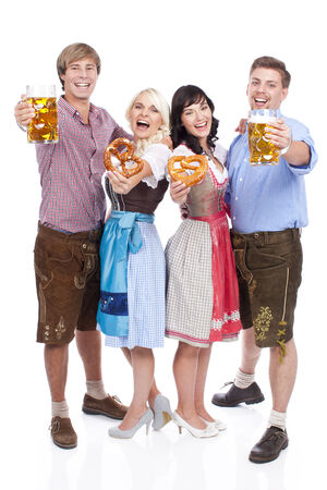 Four young people in traditional costume  with beer glassesの写真素材