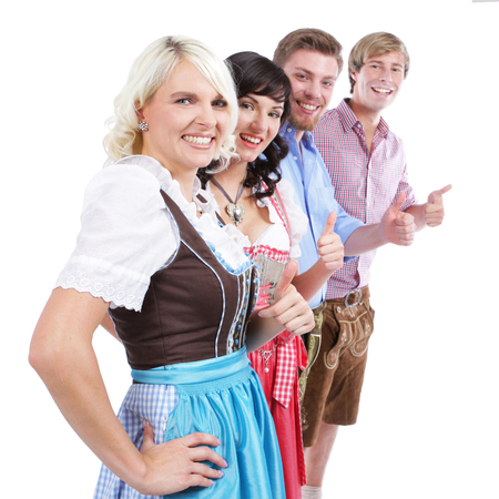 Four young people in traditional costume with thumbs upの写真素材