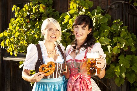 young woman couple in traditional costume  with beer glassesの写真素材