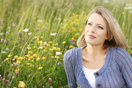 Happy middle aged woman in wild flower field Happy middle aged woman in wild flower field