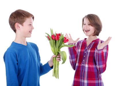 Happy girl gets flowers from a boy isolatedの写真素材