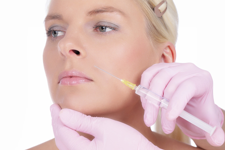 Woman gets beauty treatment in her faceの写真素材