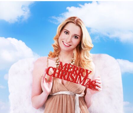 Woman angel with merry christmas sign and sky backgroundの写真素材