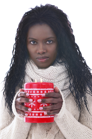 Black african woman with a red candle looking at cameraの写真素材