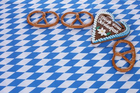 Three petzels and a ginger heart lying on a blue and white checkered table clothの写真素材