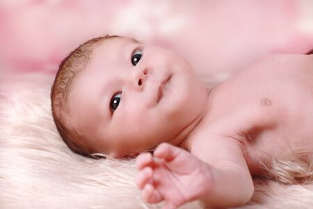 newborn baby lying on a fake furの写真素材