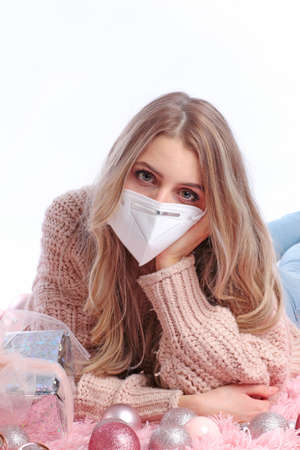Sad girl with facemask with xmas ornamentsの写真素材