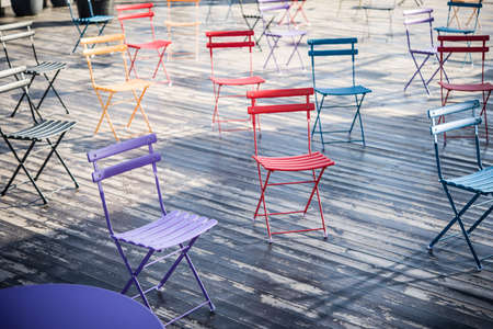 Colored folding chairs for a seminar or training on an open wooden terraceの写真素材