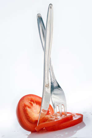 Disposable plastic fork and knife and chopped tomatoの写真素材