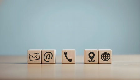 Conceptual image of contact us icons on wooden cubes over blue backgroundの素材
