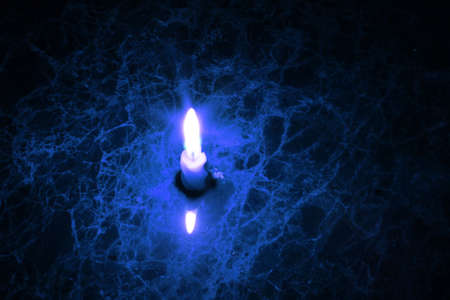 Candle on marble glows blueの写真素材