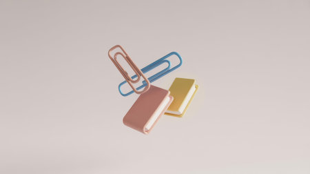 A minimalist 3D rendering of three pastel-colored paper clips and two small books suspended in the air against a light background. Clear details and vibrant colors enhance visual appeal.の素材