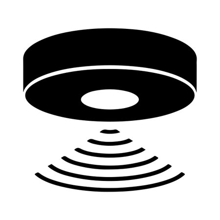 A black silhouette of a round device with a central circle emits concentric wave patterns, suggesting wireless signal transmission.のイラスト素材