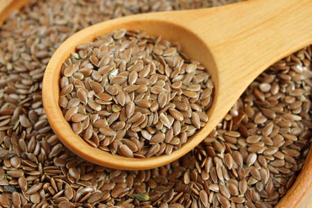 Flax seeds on the wooden plate and wooden spoonの写真素材