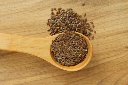 Flax seeds on the wooden plate and wooden spoonの写真素材