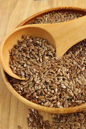 Flax seeds on the wooden plate and wooden spoonの写真素材