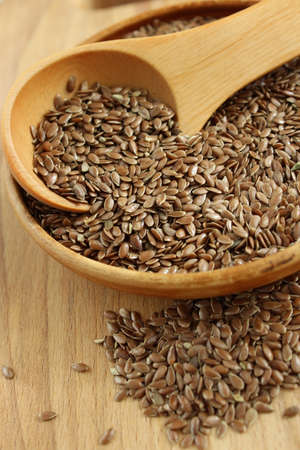 Flax seeds on the wooden plate and wooden spoonの写真素材