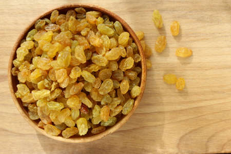 Golden grapes on a plate and a wooden backgroundの写真素材