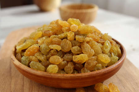 Golden grapes on a plate and a wooden backgroundの写真素材