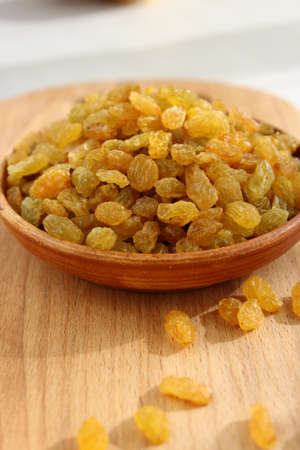 Golden grapes on a plate and a wooden backgroundの写真素材