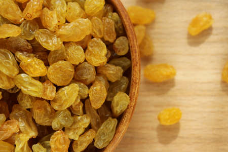 Golden grapes on a plate and a wooden backgroundの写真素材