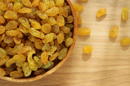 Golden grapes on a plate and a wooden backgroundの写真素材