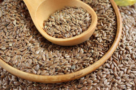 Flaxseed in a plate and on a wooden backgroundの写真素材