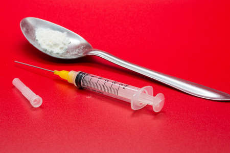 Syringe and Heroien isolated on red background.の写真素材