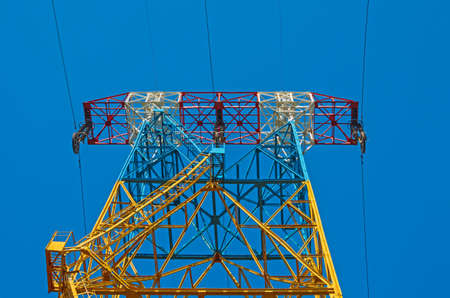 High voltage pylons line electricity with cable against the blue sky