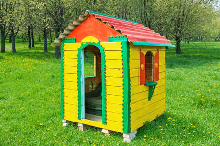 A small children's playhouse on the lawn in the city park in early springの写真素材