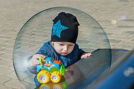 A little boy inside a glass ball symbolizing the protection of children from viral infectionの写真素材