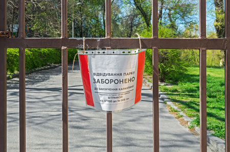 Lettering on plate - visiting the park is prohibited until end of quarantine. Violation of sanitary measures is punishable by fine from 17,000 to 34,000 hryvniaのeditorial素材