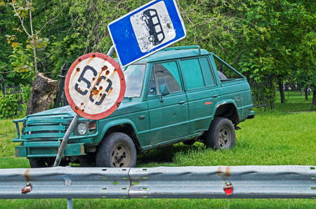 Damaged road signs on background old broken carの写真素材