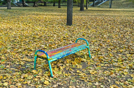 Multicolored bench in old park in the rays of evening sunの写真素材