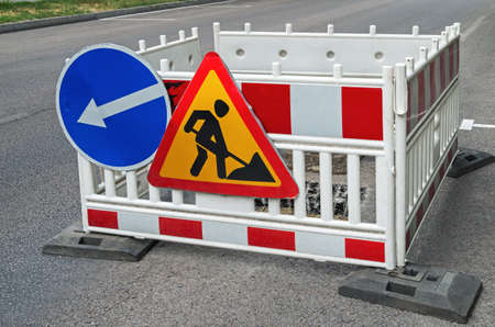 Plastic fence with warning signs during road repairの写真素材