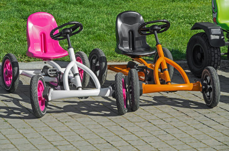 Two children's four-wheeled bicycles on pavement at the amusement parkの写真素材