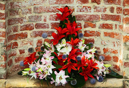 Flowers arrangement  in the foreground with a brick wall