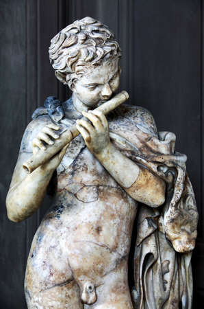 Ancient Roman statue of a young boy with flute の写真素材