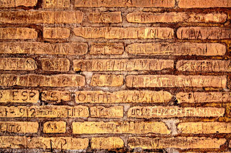 The historical brick wall witth engraved inscriptions の写真素材
